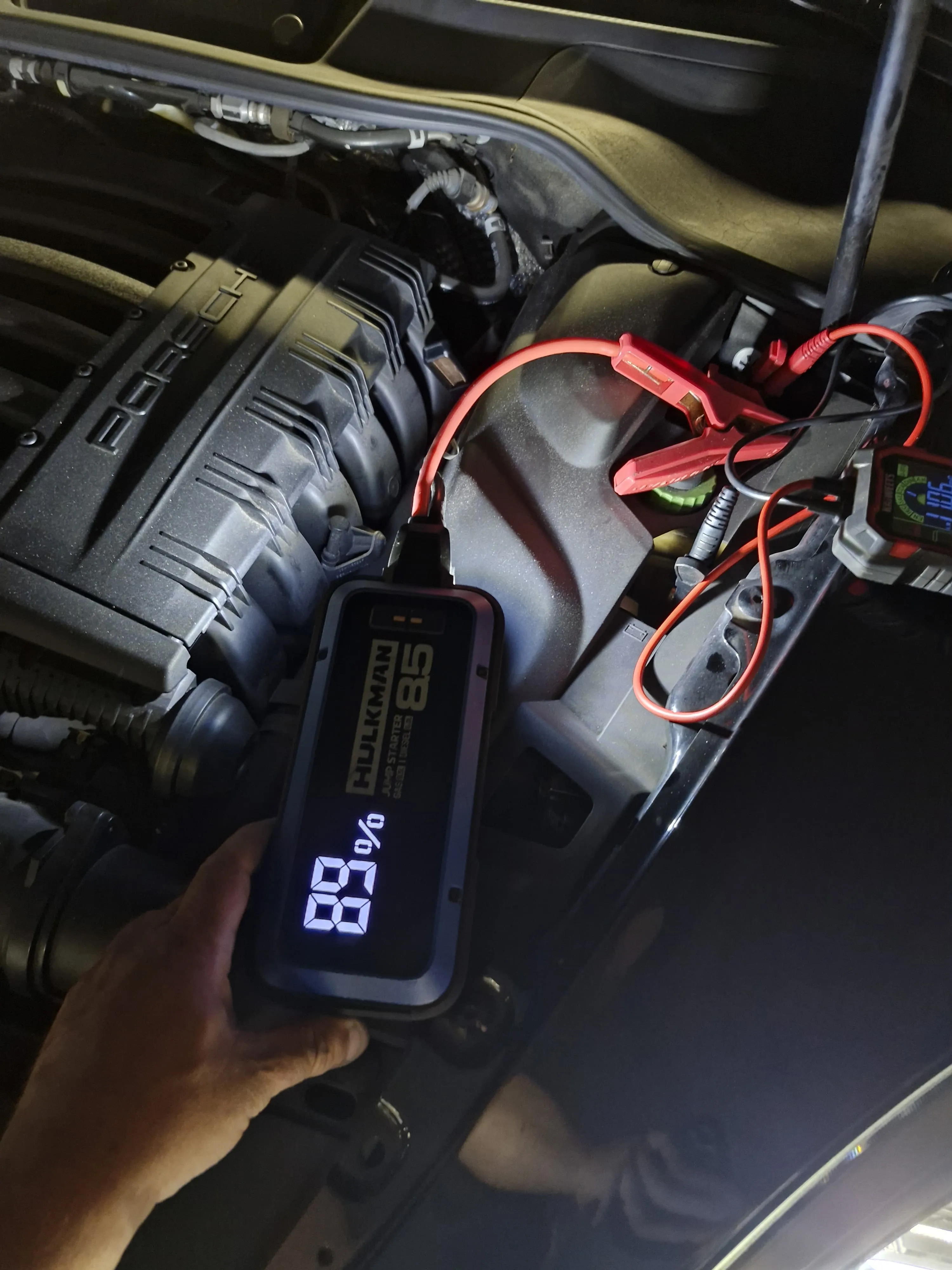 Portable jump starter and test equipment connected in a Porsche